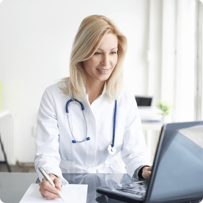 Shot of a female doctor working on medical expertise while sitting at desk in front of laptop.